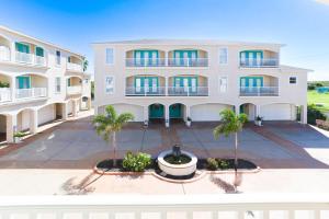 an apartment building with palm trees in front of it at Entire House - Spacious 3 Bedroom on the Island in Corpus Christi