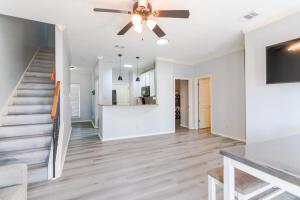 a living room with a staircase and a ceiling fan at Entire House - Spacious 3 Bedroom on the Island in Corpus Christi
