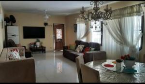 a living room with a table and a couch at Cantinho Charmoso no Guarujá in Guarujá