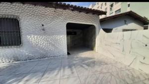 a white brick building with a large doorway at Cantinho Charmoso no Guarujá in Guarujá