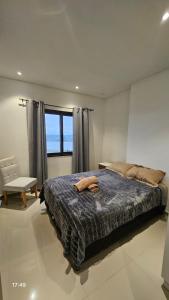 エンカルナシオンにあるRefugio Paranáのベッドと椅子と窓のある寝室