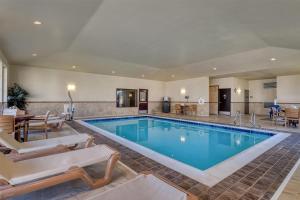 a pool in a hotel with chairs and a table at Best Western Shelby Inn & Suites in Shelby