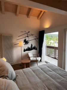 1 dormitorio con 1 cama y una rama de árbol en la pared en Appartamento La Téza, en Lavarone