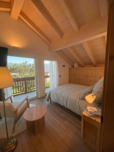 Un dormitorio con una cama y una ventana grande. en Appartamento La Téza, en Lavarone