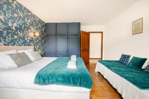 a bedroom with two beds with green and white sheets at Spacious center parking balconies in Taninges