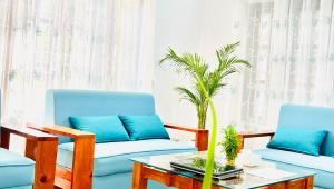 a living room with two blue couches and a table at Himalayan Tranquil Stay in Burhānilkantha