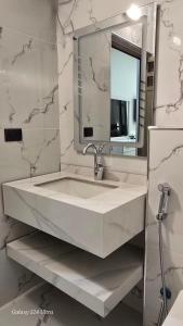 een witte badkamer met een wastafel en een spiegel bij Jeeso hotel in Jerash +48 foto's