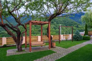 a park with a wooden bench next to a tree at DiliVita Rest House in Dilijan