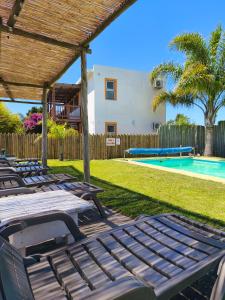 a group of lounge chairs and a swimming pool at Apartamentos La Playa in Piriápolis