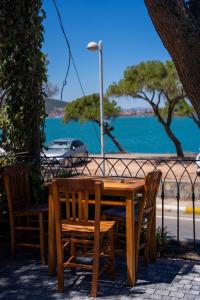 a wooden table and chairs with a view of the water at Sefa Çamlı Palas in Ayvalık
