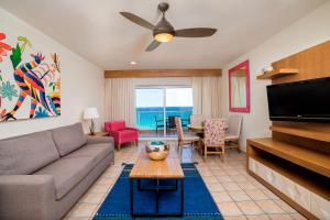 a living room with a couch and a flat screen tv at Villa Del Palmar in Cabo San Lucas