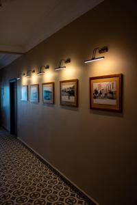 a hallway with a row of pictures on a wall at Sefa Çamlı Palas in Ayvalık