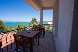 a balcony with tables and chairs and a view of the ocean at Sefa Çamlı Palas in Ayvalık