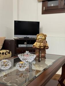a teddy bear sitting on a glass table in a living room at Traditional Memories 2 in Tríkala