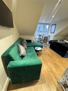 sala de estar con sofá verde y cama en Apartment 5- 216 High Street, en Arbroath