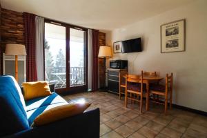 a living room with a couch and a table at Studio cabine lumineux et calme, au centre de Flaine Foret in Flaine