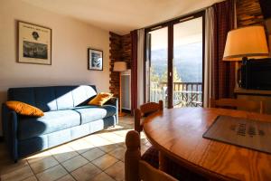 a living room with a couch and a table at Studio cabine lumineux et calme, au centre de Flaine Foret in Flaine