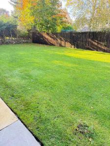 a yard with a fence and a green lawn at West Lodge - Buxton in Buxton +61 photos