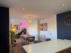 a kitchen and living room with a table and chairs at West Lodge - Buxton in Buxton