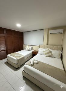 ein Hotelzimmer mit zwei Betten und einem großen Fenster in der Unterkunft Hotel ladymar cartagena in Cartagena de Indias