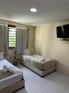 ein Schlafzimmer mit zwei Betten und einem Flachbildfernseher in der Unterkunft Hotel ladymar cartagena in Cartagena de Indias + 7 Fotos