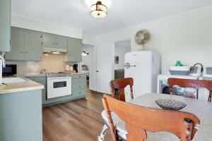 eine Küche mit grünen Schränken, einem Tisch und einem Kühlschrank in der Unterkunft Relaxing River Getaway for 5 Unwind and Unplug in Schumannsville