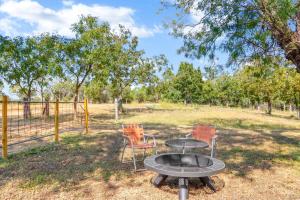 ein Grill mit zwei Stühlen und einem Tisch auf einem Feld in der Unterkunft Relaxing River Getaway for 5 Unwind and Unplug in Schumannsville