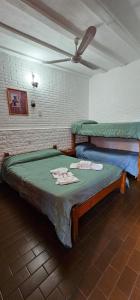 a bedroom with two beds and a ceiling fan at Hotel Francesco in Mina Clavero
