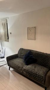 a couch sitting in a living room next to a wall at Modern 1-Bed Flat in Crystal Palace Sydenham in Sydenham