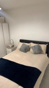 a large bed with a black headboard and pillows at Modern 1-Bed Flat in Crystal Palace Sydenham in Sydenham