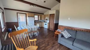 a living room with a couch and a table and chairs at Motel et Chalets l'Acadien sur mer in Petit Rocher