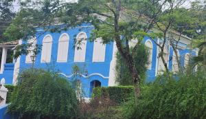 a blue and white building with trees in front of it at Quinta das Águas Hotel in Itapira