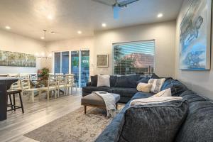 a living room with a blue couch and a dining room at 31| Pool Palace in St George with Snow Canyon View in Santa Clara