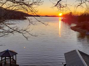 una puesta de sol sobre un lago con cenador en Reel It In, en Dandridge