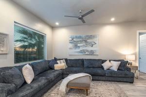a living room with a blue couch and a ceiling fan at 31| Pool Palace in St George with Snow Canyon View in Santa Clara