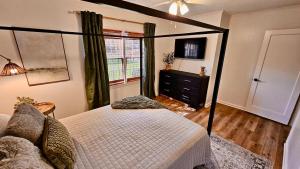 ein Schlafzimmer mit Himmelbett und Fenster in der Unterkunft Center of Town! Near Hospital and VSU, Gameroom & Fire-pit, Pet Friendly in Valdosta
