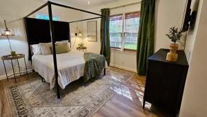 Schlafzimmer mit Himmelbett und Fenster in der Unterkunft Center of Town! Near Hospital and VSU, Gameroom & Fire-pit, Pet Friendly in Valdosta