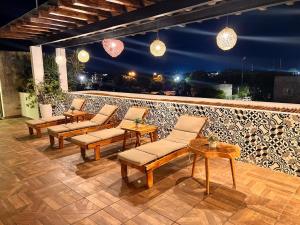 a row of chairs and tables on a patio at night at Hotel Ko'ox Wenne in Tulum