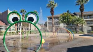 a water fountain in a park with palm trees at 19| Vue at Green Valley with Community Pool in St. George