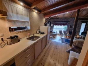 a kitchen with a sink and a refrigerator and a living room at Stone View Nest - By Ski Alure in Arachova +11 photos