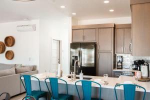 a kitchen with a table and blue chairs in a room at 20| Vue at Green Valley with Community Pool in St. George