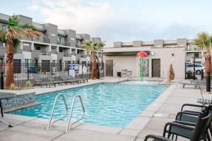 a swimming pool with chairs and a building at 20| Vue at Green Valley with Community Pool in St. George