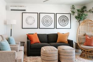 a living room with a black couch and four pictures on the wall at 20| Vue at Green Valley with Community Pool in St. George
