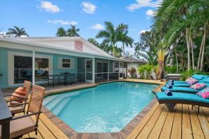 una piscina con sedie e una casa di Blue Tide Bungalow a Bradenton