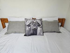 ein Bett mit einem Bild einer Kuh drauf in der Unterkunft Kruger Boutique Backpackers in Marloth Park
