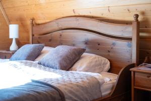 two beds in a bedroom with a wooden wall at Góralski domek z kominkiem w dużym ogrodzie pełnym zieleni w spokojnej okolicy, blisko atrakcji Podhala in Łopuszna