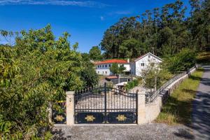 a gate to a driveway with houses in the background at Casa Das Fontes Ponte De Lima - Jaccuzzi And Pool in Ponte de Lima