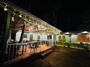 a building with a patio with tables and chairs at night at Seaside Beach Resort in Diveagar