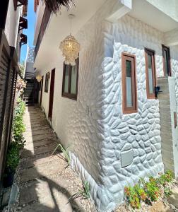 a white building with a window and a chandelier at Manay Flats in Jericoacoara