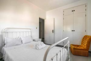 a white bedroom with a bed and a chair at Casa Das Fontes Ponte De Lima - Jaccuzzi And Pool in Ponte de Lima +77 photos